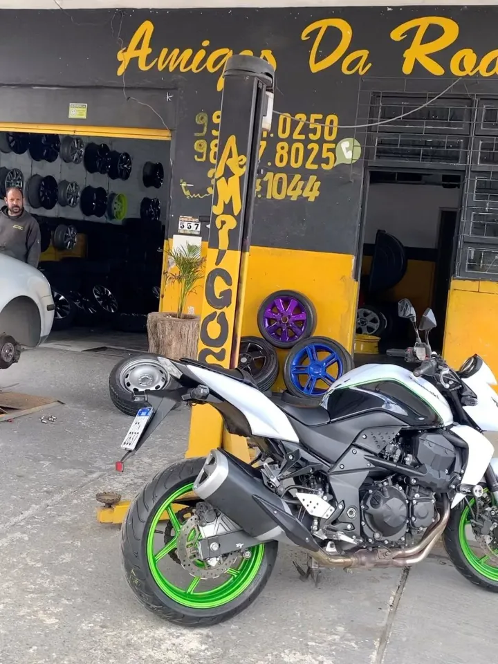 Moto com rodas pintadas de verde em frente à Amigos da Roda, na Cavalhada